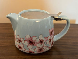 Adorable ceramic mini teapot with metal lid. Holds about 2 servings. Lt blue with pink cherry blossoms.